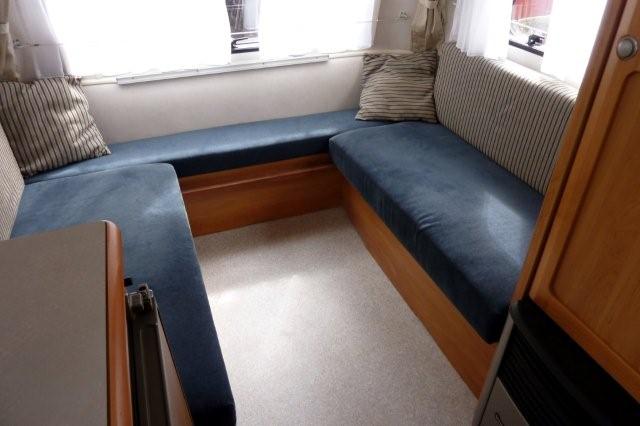l'intérieur est en velours bleu et les coussins blancs et bleus, les boiseries couleur poirier